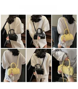 Detailed view of mini bowling bag with plush bear charm and dual zip closure