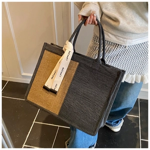 Detail of a large contrast canvas tote bag with textured grey khaki panels and ribbon strap