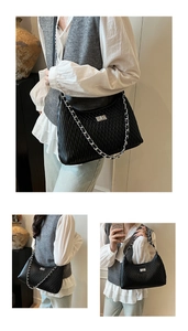 Detail of black matelassé shoulder bag featuring silver chain strap and metal turn-lock