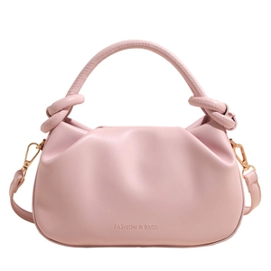 Detail of pink bucket bag with knotted handle, pleated design and metallic hardware