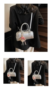 Detail of silver boston bag with a cute bear charm and textured metallic finish