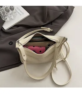Gros plan du sac bandoulière beige plissé montrant l'espace intérieur spacieux
