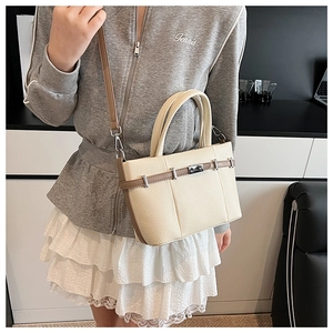Détail du sac cabas en cuir crème avec lanières marron et ferrures en métal argenté