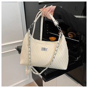 Close-up of off-white pleated shoulder bag with silver chain and metal twist lock