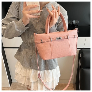 Vue détaillée du sac à main en cuir rose avec fermoir métallique et bandoulière réglable