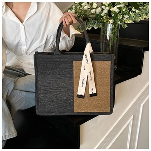 Detail of color-block felt tote bag in dark grey and brown with ribbon decoration