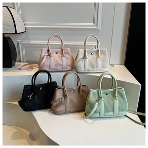 Vertical view showing multiple pleated bucket bags in five colors on art pedestals