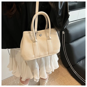 Detail of beige pleated bucket bag showing vertical texture and silver hardware