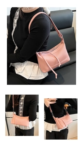Detailed view of pink pleated shoulder bag featuring drawstring texture and soft faux leather
