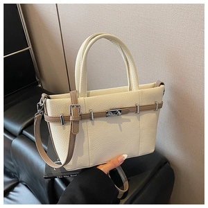 Détail du sac cabas en cuir crème avec texture grainée et bandoulière réglable