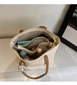 Detail shot of the large tote bag's interior storage compartments and smooth lining