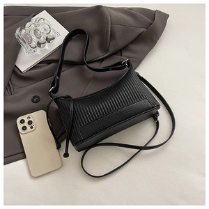 Close-up of black PU leather underarm bag with vertical stripes and drawstring details