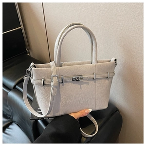 Détail du cuir grainé beige et de la boucle argentée sur le sac à main seau élégant