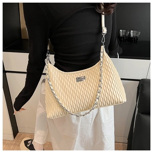 Detail of beige pleated cloud bag with silver twist lock and chunky metal chain strap