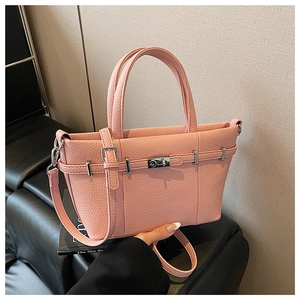 Détail du sac à main rose à motif litchi avec fermoir tournant et bandoulière
