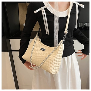 Detailed view of beige crossbody bag with wavy pleated texture and silver twist lock