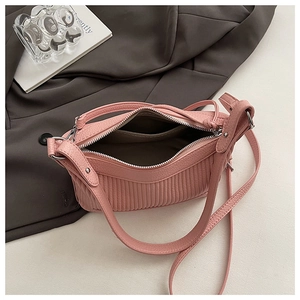 Detail view of pink ruched shoulder bag with silver zipper and interior compartment