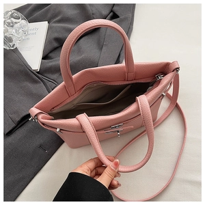 Vue détaillée du sac cabas rose en cuir grainé avec compartiments intérieurs et boucles