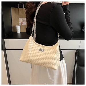 Detail of beige pleated hobo bag with silver chain strap and rectangular metal clasp