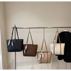 Detail view of large tote bags in four colors featuring decorative silk scarves on handles