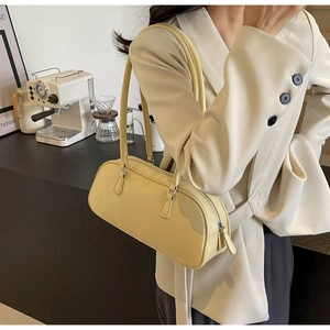 Detail of a yellow ballet-style baguette bag with dual slim straps and silver zipper