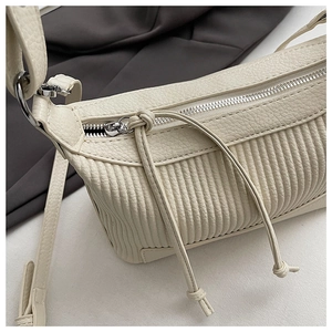 Detail of off-white pleated shoulder bag with silver zipper and leather drawstrings