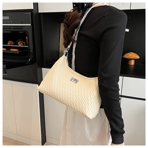 Close-up of off-white pleated shoulder bag with silver metallic clasp and chain strap