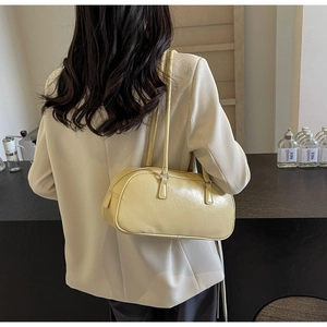 Detail view of cream leather ballet-style bow shoulder bag with silver metal hardware