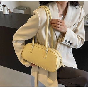 Chic light yellow leather boston bag shown with chic beige blazer for elegant look