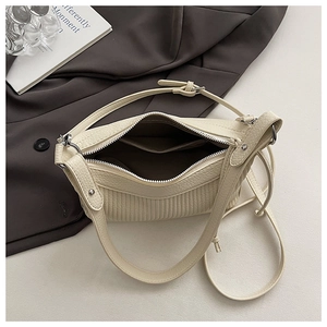 Detail view of the beige dumpling bag inner space with adjustable leather shoulder strap