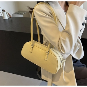 Detailed side view of a cream ballet-style bow shoulder bag with slim straps and zip top