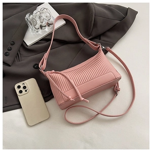 Detail of pink pleated leather underarm bag featuring vertical stitching and dual straps