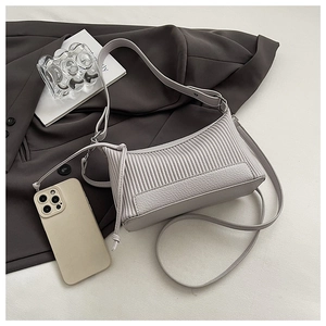Detail of light grey pleated shoulder bag showing vertical texture and leather base