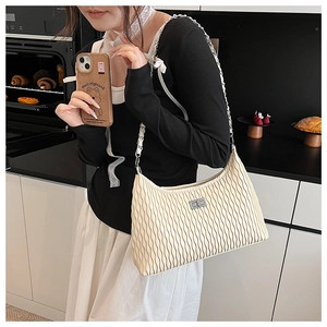 Detail of beige pleated shoulder bag with silver chain strap and twist lock closure