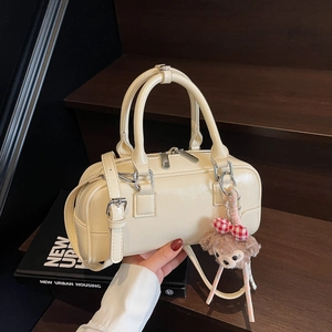 Cream faux leather Boston bag with plush charm and adjustable shoulder strap