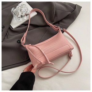 Detail of pink pleated underarm bag showing vertical stitching and silver hardware