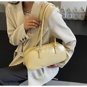Detail showing cream yellow pleated leather texture and silver zipper on the shoulder bag
