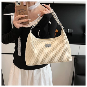 Detail of off-white hobo bag with vertical pleats and silver metal twist lock closure