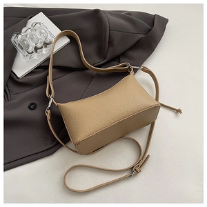 Close-up of khaki litchi grain leather crescent bag with silver hardware and zipper