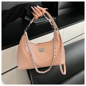 Detail of pink pleated texture shoulder bag featuring silver chain and rectangular turn-lock