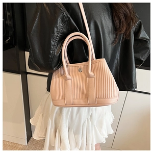 Detail of pink pleated leather bucket bag showing vertical quilting and metal snap closure