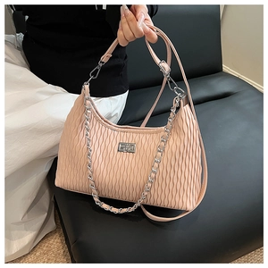 Detail of pleated apricot pink shoulder bag with silver chain strap and metal lock