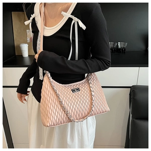 Detail of light pink pleated shoulder bag with silver turn-lock and chain decoration