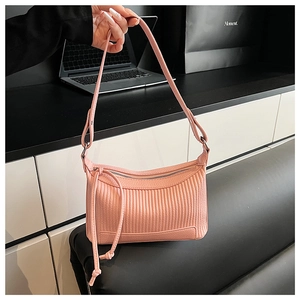 Close-up of pink pleated texture shoulder bag with drawstring fringe detail and zipper