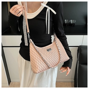 Detail of apricot pleated shoulder bag featuring wavy texture and silver chain strap