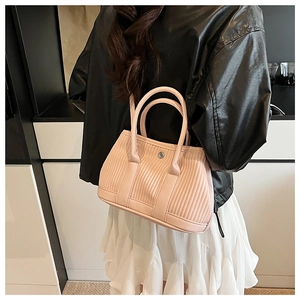 Detail of light pink bucket bag with pleated texture and silver magnetic buckle