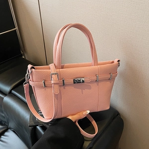 Sac à main rose texture grainée avec fermoir rotatif argenté et bandoulière
