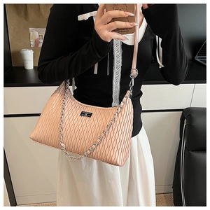 Detail of pink pleated underarm bag featuring silver metal clasp and chunky chain link