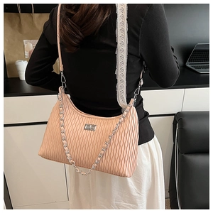 Detail of soft apricot pleated shoulder bag with silver chain and metal twist lock