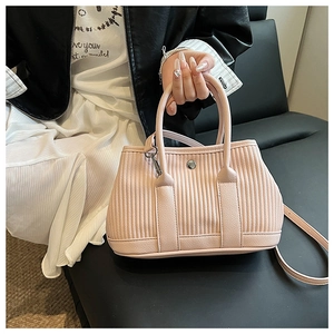 Detail showing the pink pleated faux leather texture and metallic rivet on bucket bag